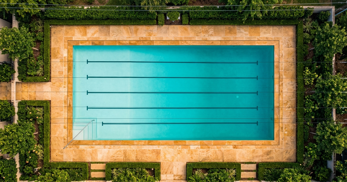 Tape measure stretched across a backyard swimming pool with a notepad showing length, width, and depth measurements